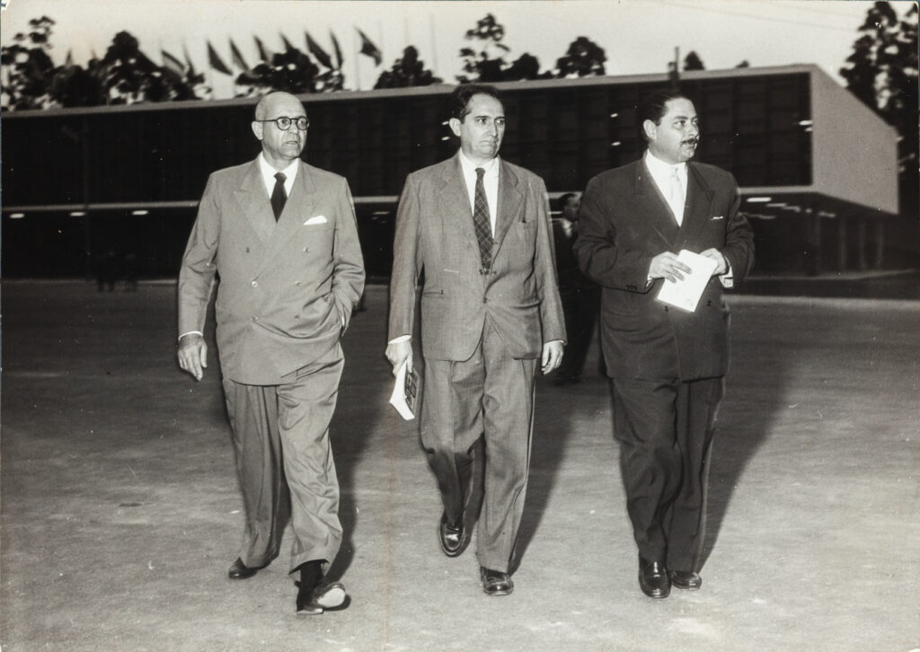 O presidente da Bienal de São Paulo Francisco Matarazzo Sobrinho, conhecido como Ciccillo Matarazzo, Mario Pedrosa e o secretário geral da segunda Bienal Arturo Profili em frente ao Pavilhão da Bienal, 1953? imagem: autoria desconhecida coleção Fundação Bienal de São Paulo/Arquivo Histórico Wanda Svevo